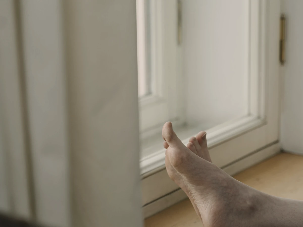 Bare feet resting up on a windowsill by a bright window