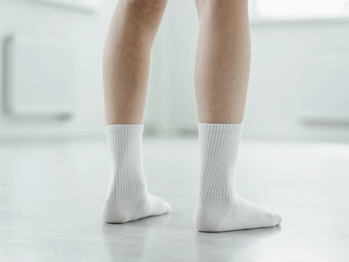 A person’s feet in plain white socks, seated indoors