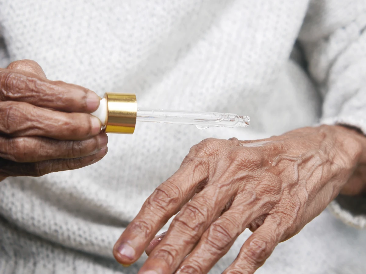 A close view of an older person’s hands, skin texture visible