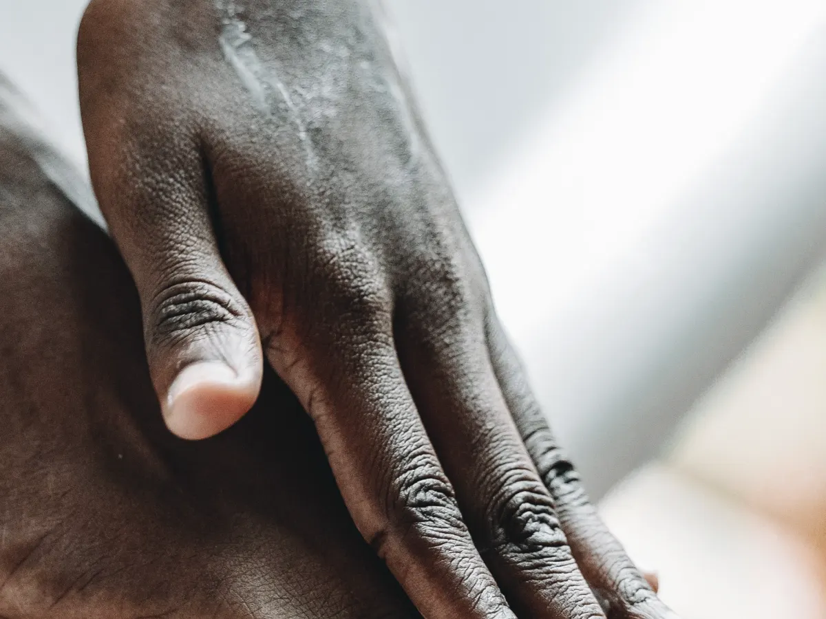 A hand resting on a bare foot, paying attention to a tingling sensation