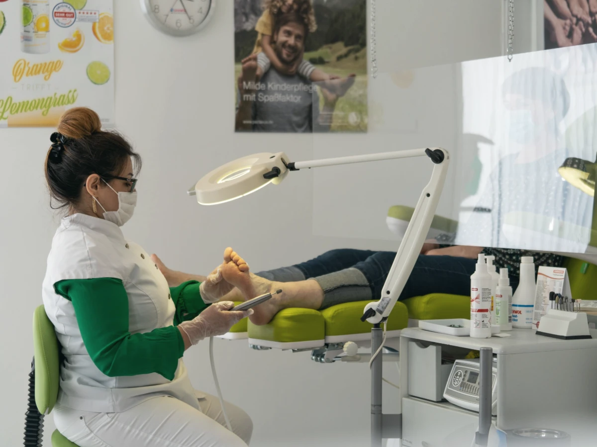 A clinician working on a patient’s foot in a treatment room